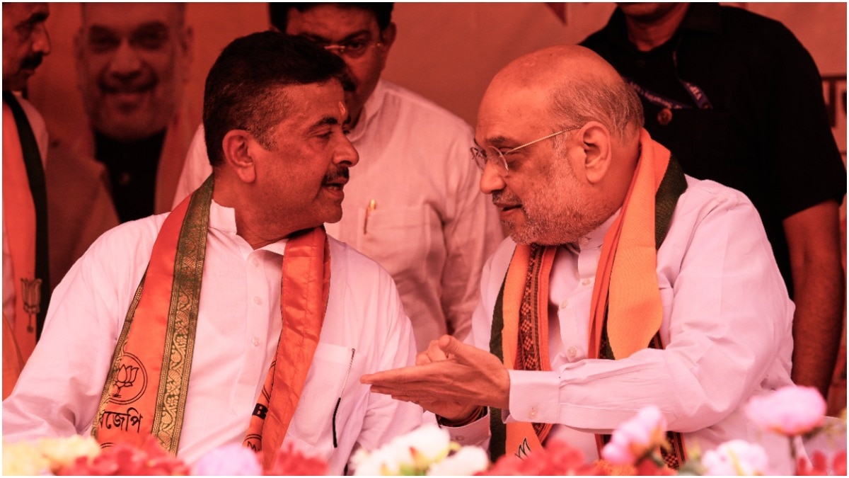 Home Minister Amit Shah, right, talks to West Bengal Opposition leader Suvendu Adhikari, at a meeting in Kolkata