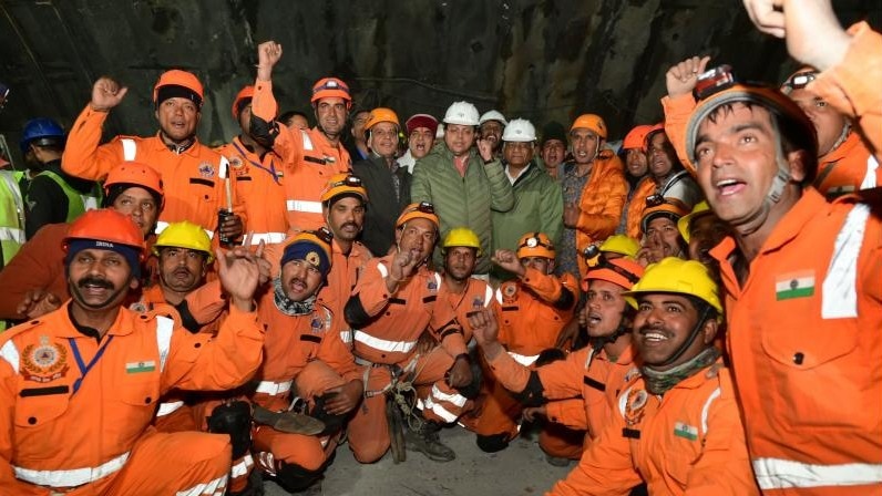 सिल्कयारा सुरंग से 41 मजदूरों के सेफ रेस्क्यू के बाद पुष्कर सिंह धामी और वी.के. सिंह बचाव कर्मियों के साथ. (File Photo: PTI) 
