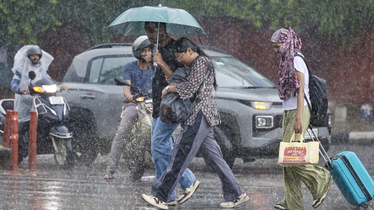 जयपुर में भारी मॉनसून बारिश के बीच लोग आते-जाते हुए.(Photo:PTI)