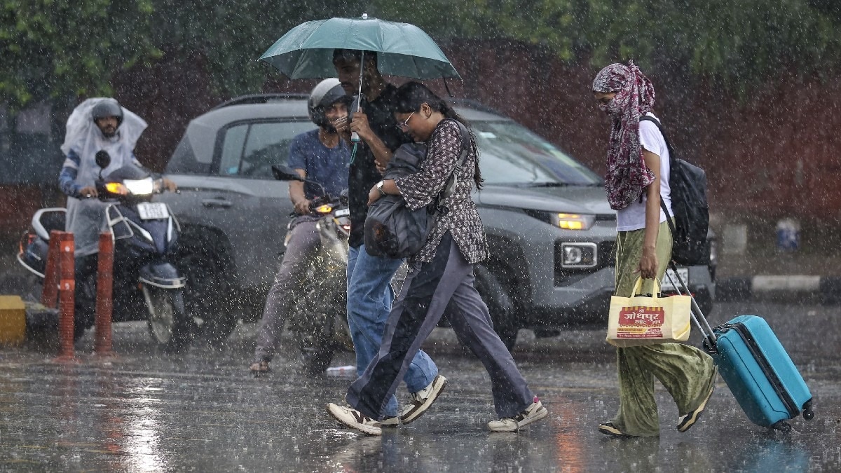 जयपुर में भारी बारिश के बीच लोग आते-जाते हुए.(File Photo:PTI)