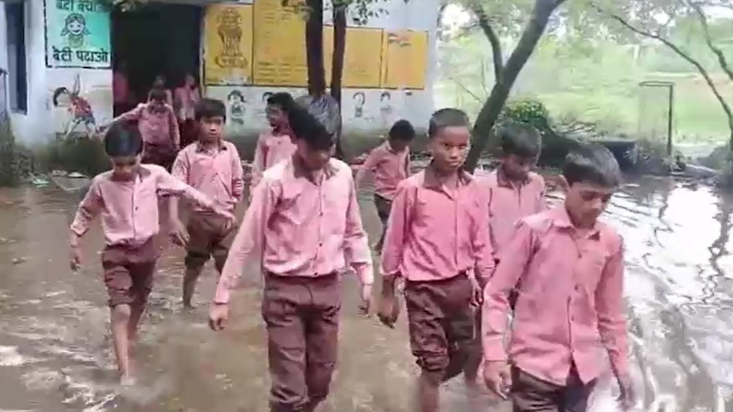 बारिश के पानी के बीच स्कूल आते-जाते बच्चे. (Photo: Screengrabs)