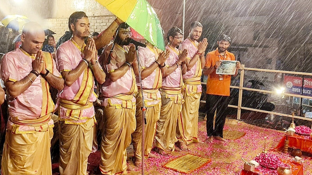 वाराणसी के दशाश्वमेध घाट पर बारिश के बीच पुजारियों ने नेपाल बाढ़ पीड़ितों को श्रद्धांजलि दी.(Photo:PTI)