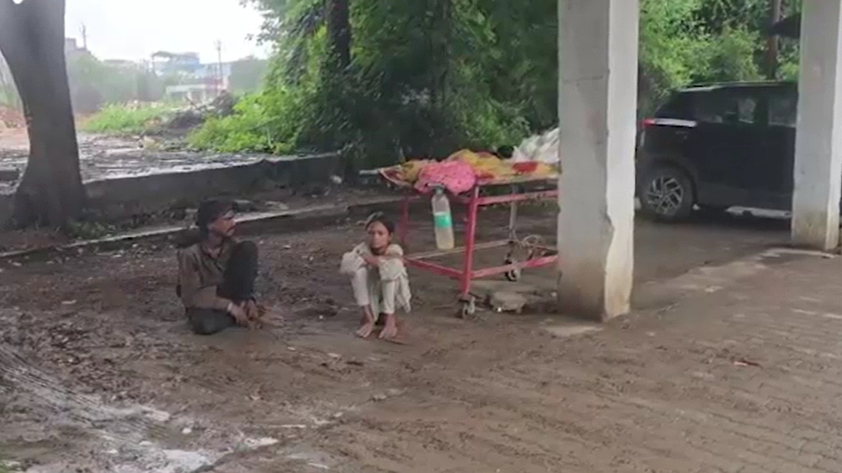 पत्नी का शव स्ट्रेचर पर रखकर घंटों बारिश में मदद का इंतजार करता रहा पति. (Photo: Screengrab)