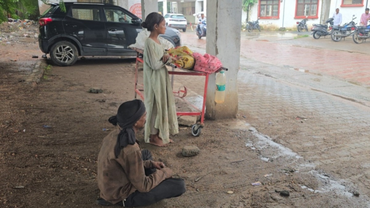  पत्नी का शव स्ट्रेचर पर रखकर घंटों बारिश में मदद का इंतजार करता रहा पति. (Photo: Screengrab)