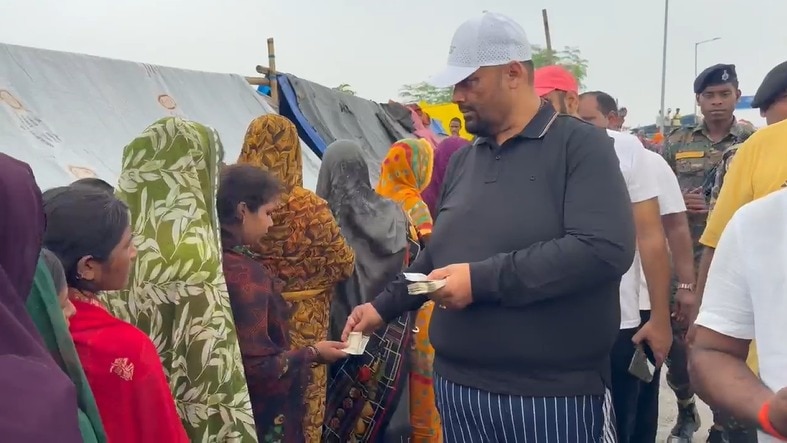 पटना के दीघा घाट पर बाढ़ पीड़ितों को पैसे बांटते पप्पू यादव. (Photo: ITG)