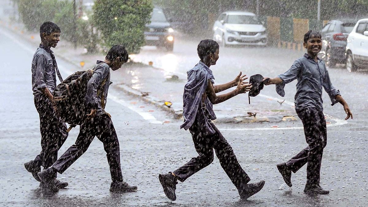 नोएडा में बारिश के दौरान सड़क पर स्कूली बच्चे. (File Photo: PTI)
