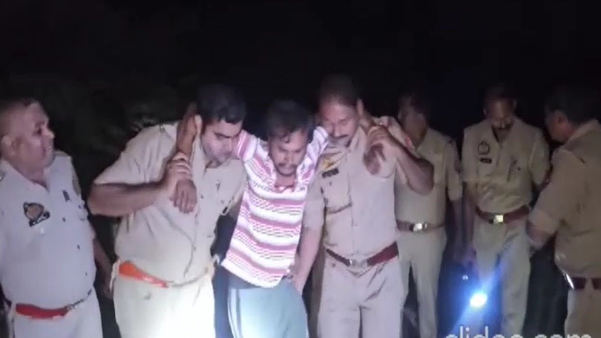 मेरठ में एनकाउंटर में घायल बदमाश को पकड़कर ले जाती पुलिस. (Photo: Screengrabs)
