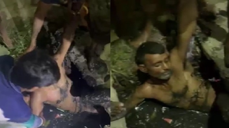 चोर को नाले से बाहर निकालते लोग. (Photo: Screengrabs)