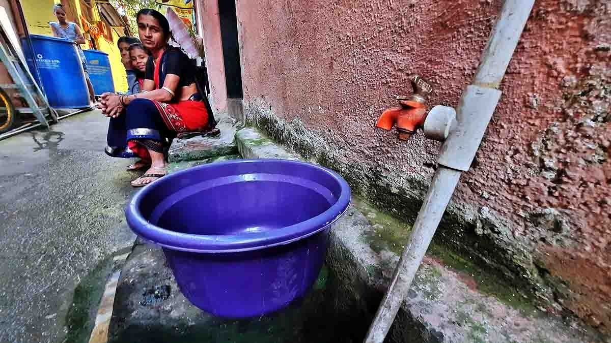मुंबई के पाटलीपाड़ा में पानी के इंतजार में बैठी महिला. (Photo: Getty)