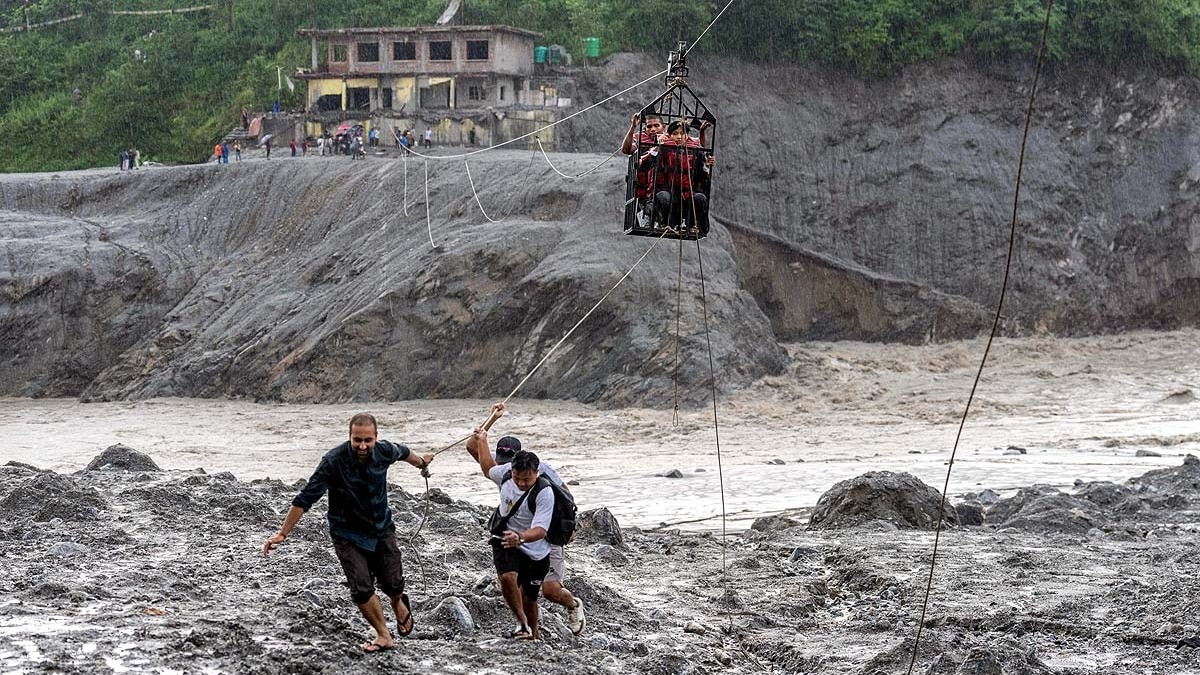 नेपाल के नुवाकोट जिले के बिदुर में नई जिपलाइन से लोगों को त्रिशुली नदी पार कराते लोग. (File Photo: AP)