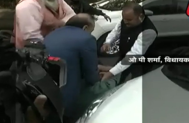 युवक की पिटाई करते ओपी शर्मा