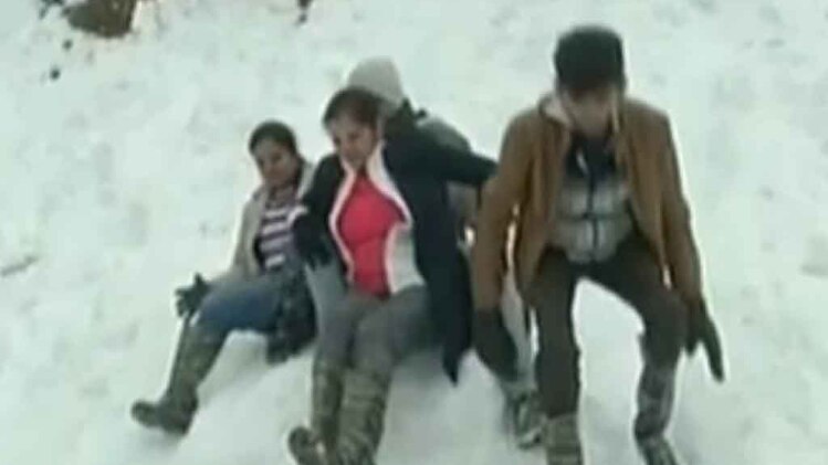 पहाड़ों पर बर्फबारी का लुत्फ उठाते पर्यटक