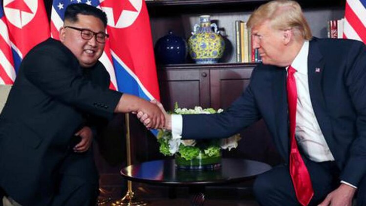 डोनाल्ड ट्रंप और किम जोंग उन हाथ मिलाते हुए