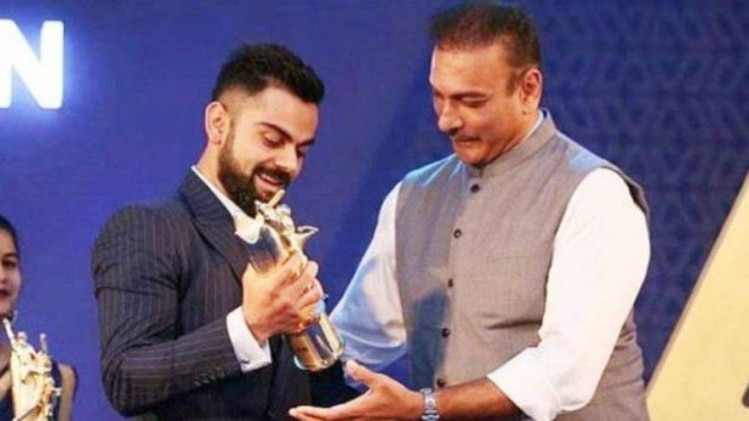 पॉली उमरीगर ट्रॉफी लेते विराट कोहली