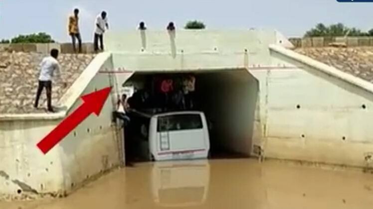 बारिश के पानी में फंसे मुसाफिर, जेसीबी मशीन से बची जान