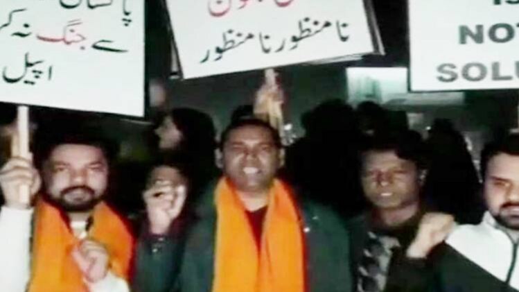 पाकिस्तान के लाहौर में शांति की अपील करते लोग(फोटो-ANI)