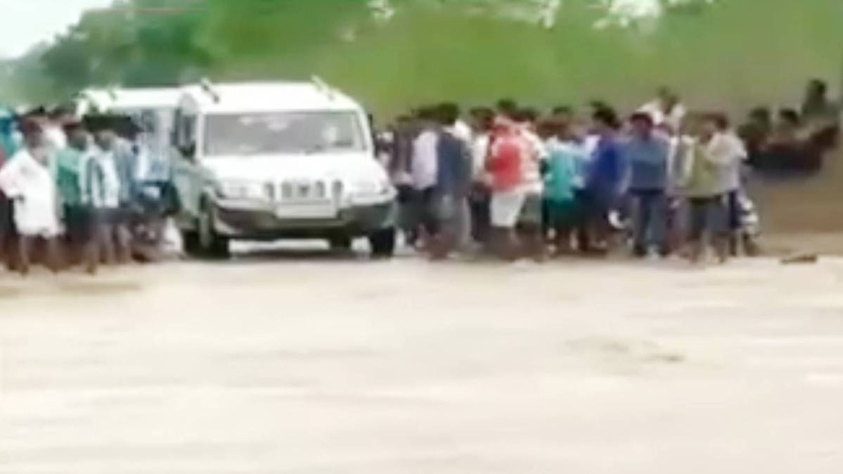 पानी की लहरों के बीच फंसी कार