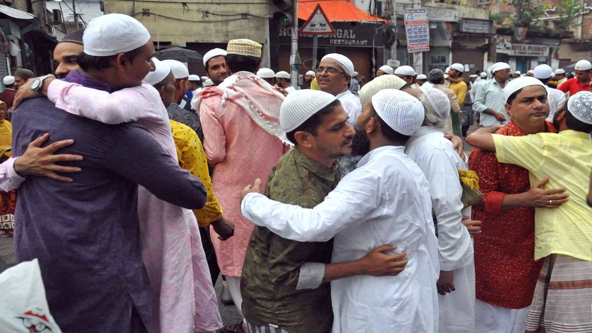 ईद पर एक-दूसरे के गले मिलते हुए लोग (फोटो-IANS)