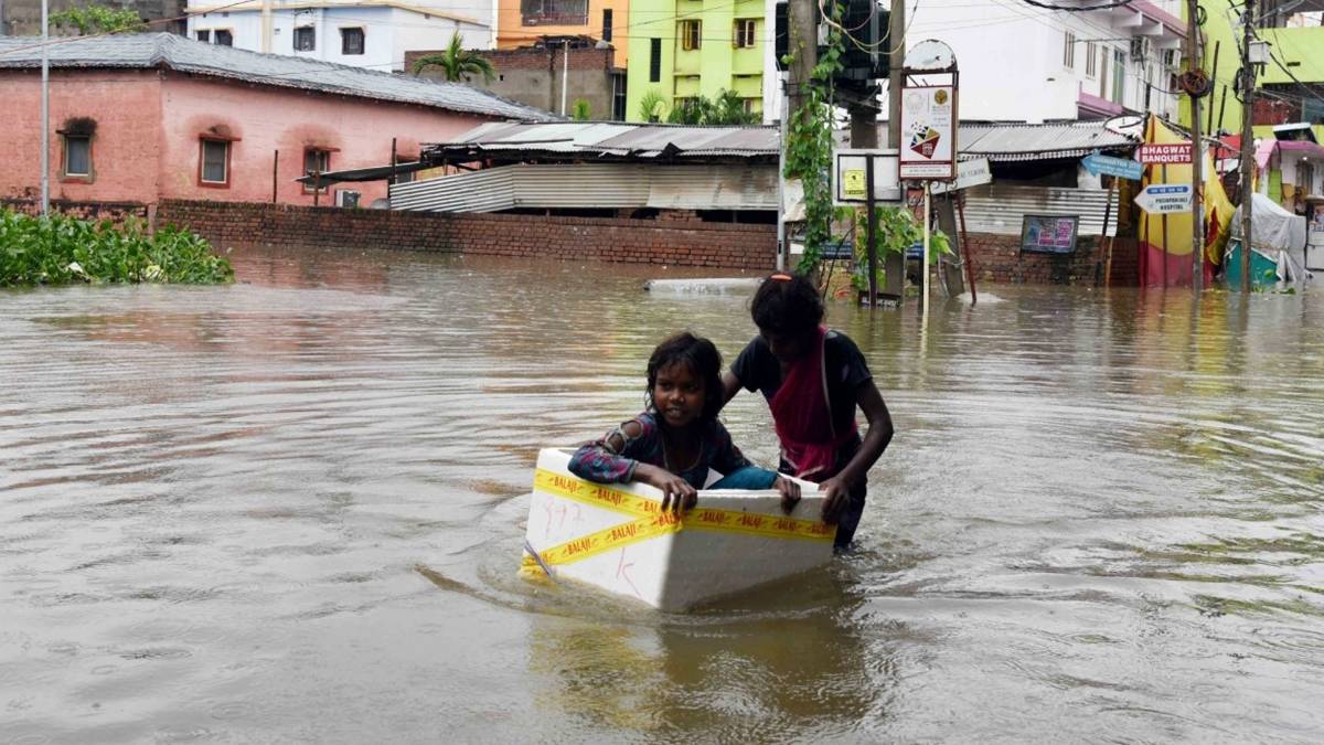 पानी से घिरे लोग (फोटो-IANS)