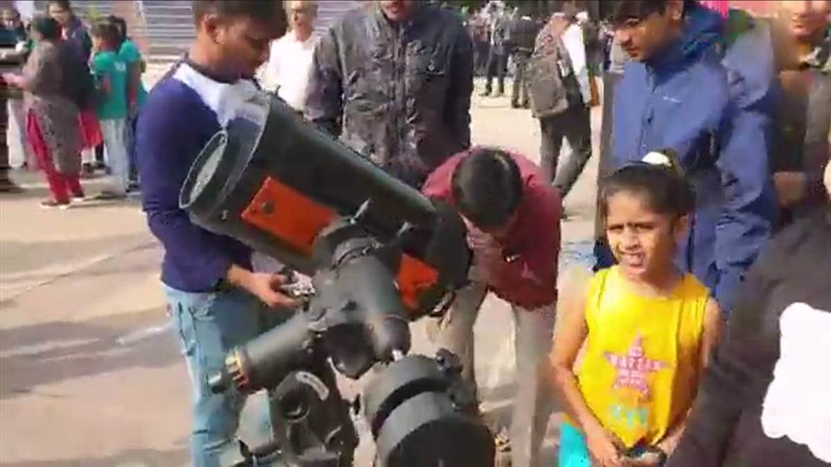 सूर्यग्रहण को अपनी आंखो में कैद करते लोग