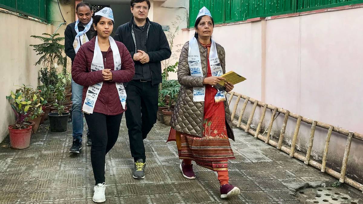 पत्नी के साथ केजरीवाल का रिपोर्ट कार्ड (फोटो-PTI)