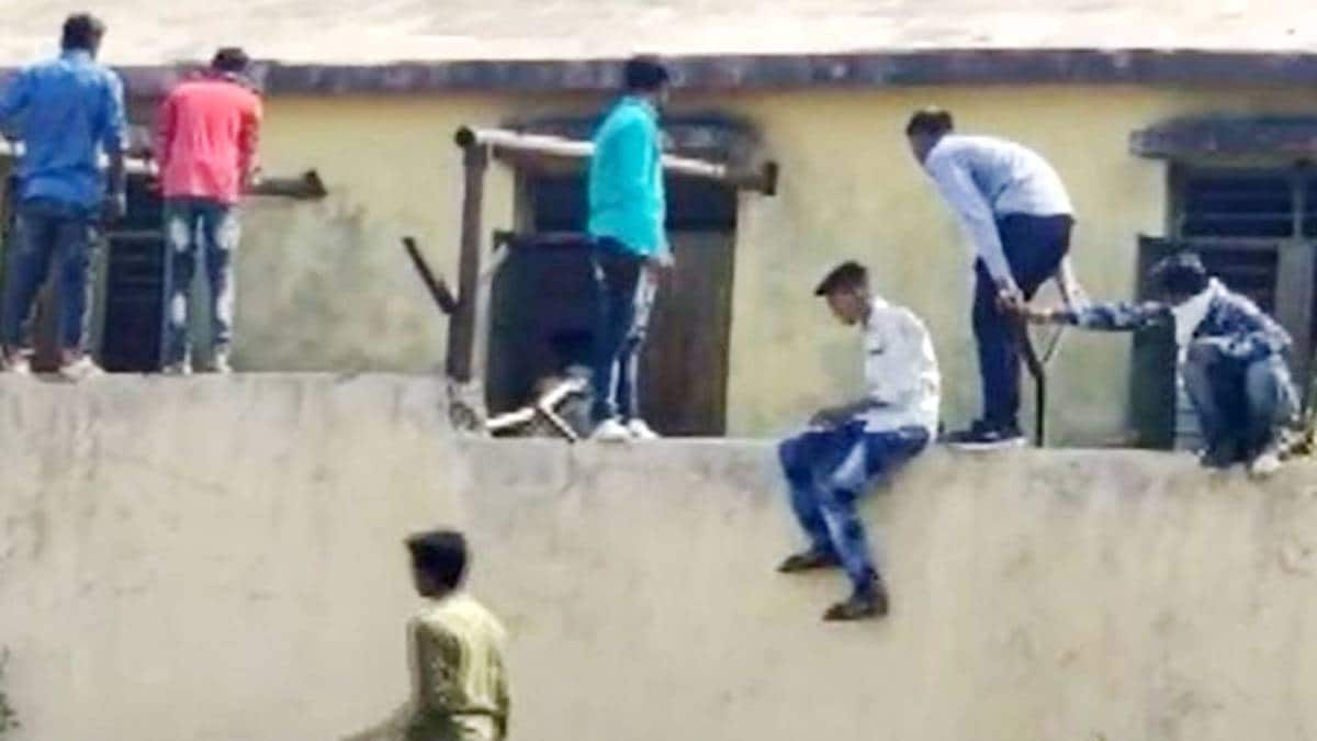 नकल की पर्चियां देते लड़के (वीडियो ग्रैब)