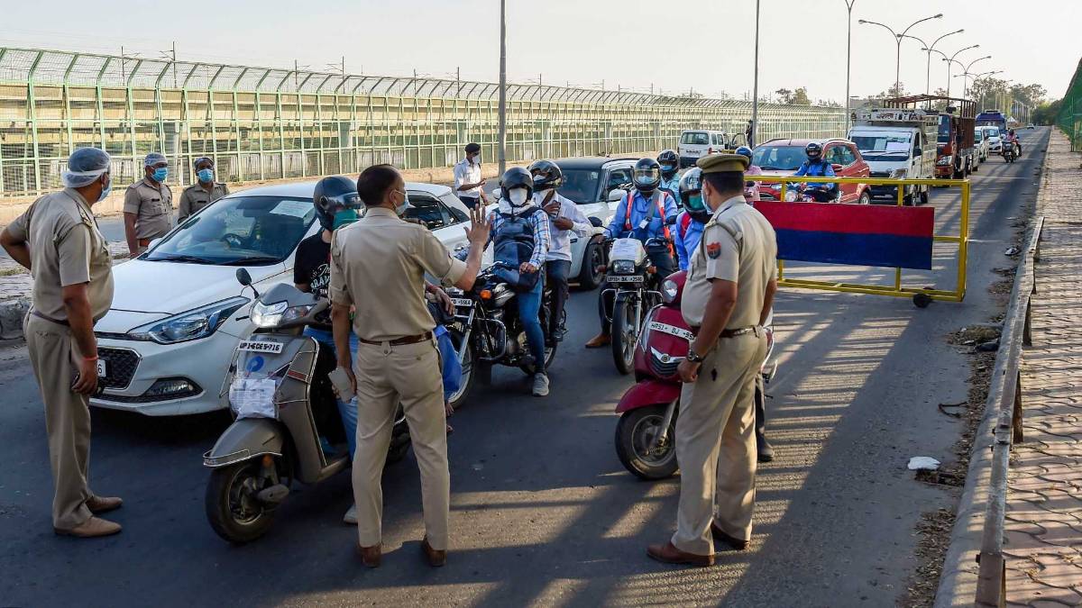 दिल्ली-नोएडा बॉर्डर पर चेकिंग करते पुलिसकर्मी