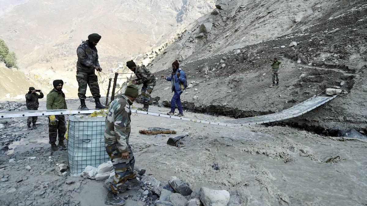 Army personnel build a bridge near Raini village