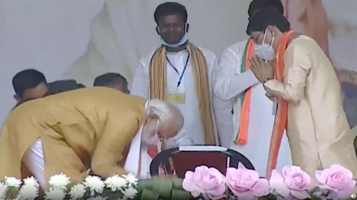 PM Modi touches BJP workers feet on Statge 
