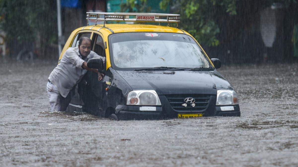 Taxi driver trying to wade through waterlogged street (File-PTI)
