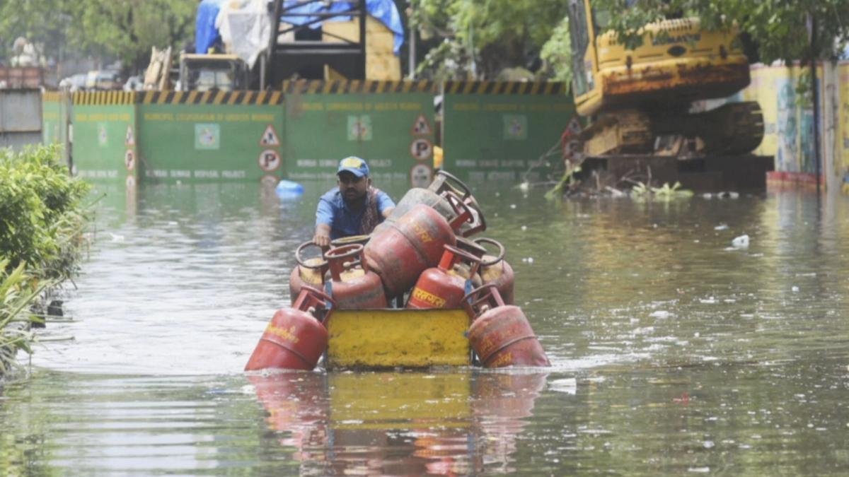 Mumbai Rain, Cylinder supplier wade through waterlogged street (File-PTI)