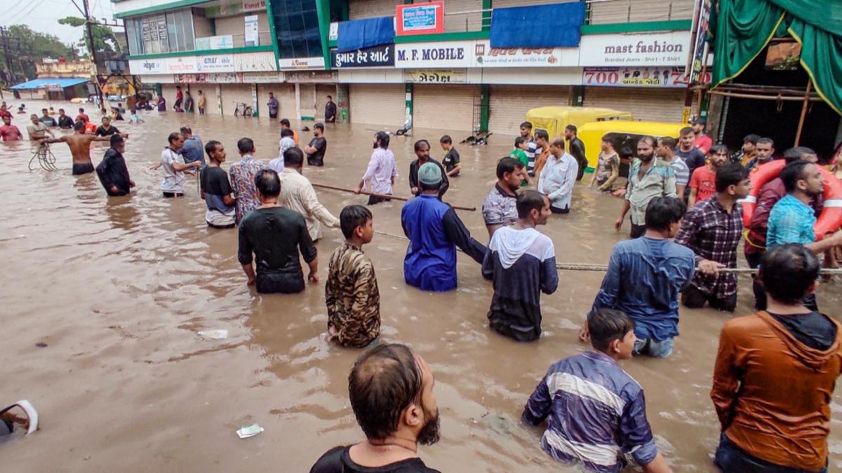 People wade through flooded area (Credit-PTI)