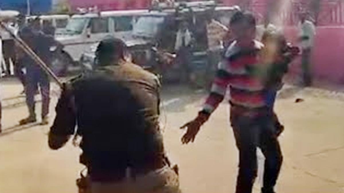 Kanpur police beating a man holding a kid 