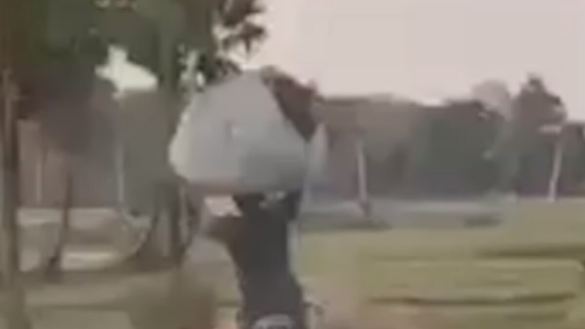 Man cycling with weight on his head
