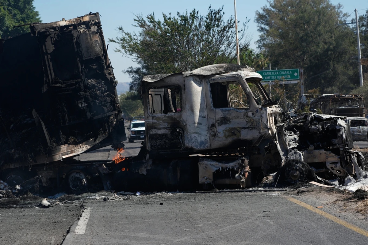 A charred truck blocks a road the day after the Mexican army killed Jalisco New Generation Cartel leader El Mencho