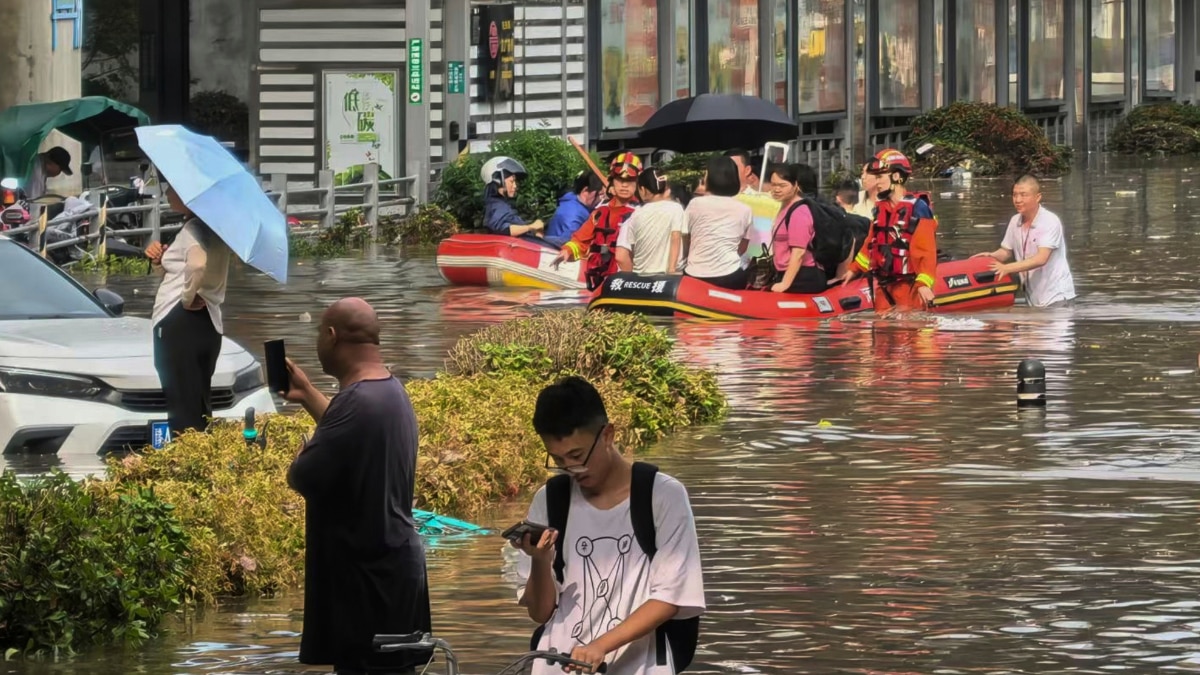 Rescue workers evacuate people from a flooded area in Zhengzhou in central China Henan province 