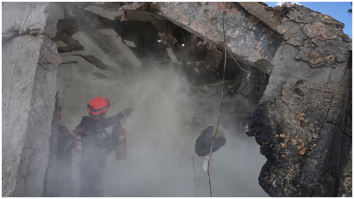 Firefighters works to extinguish fire at the site that was struck by an Iranian missile in Dimona Firefighters works to extinguish fire at the site that was struck by an Iranian missile in Dimona