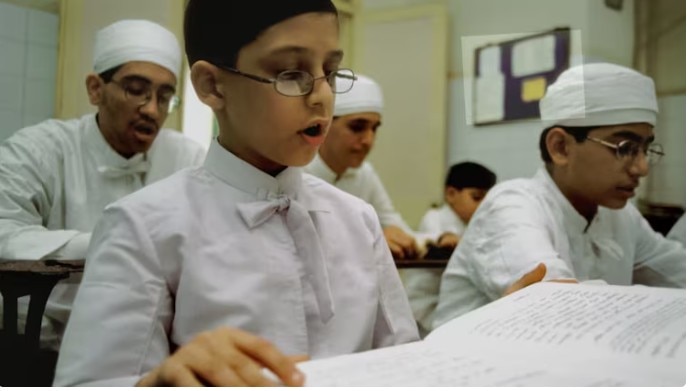 मुंबई के दादर अथोरनान मदरसे में ट्रेनिंग लेता एक पारसी लड़का. यहां छात्र पारसी धर्म के पवित्र ग्रंथ 'यस्ना' के 72 अध्यायों को कंठस्थ करते हैं, (Photo परज़ोर फाउंडेशन)