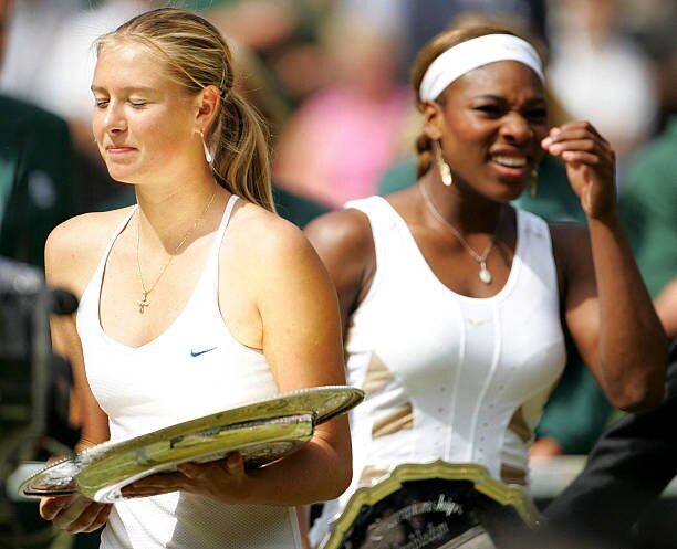 Maria Sharapova and Serena Williams carry their trophies after their final match at the Wimbledon Tennis Championships.jpg