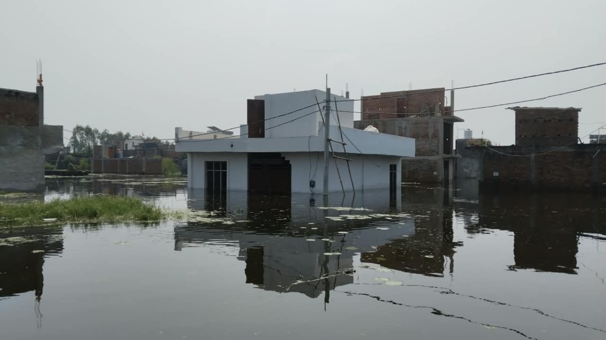 Floodwater enters the house as families wait on rooftops