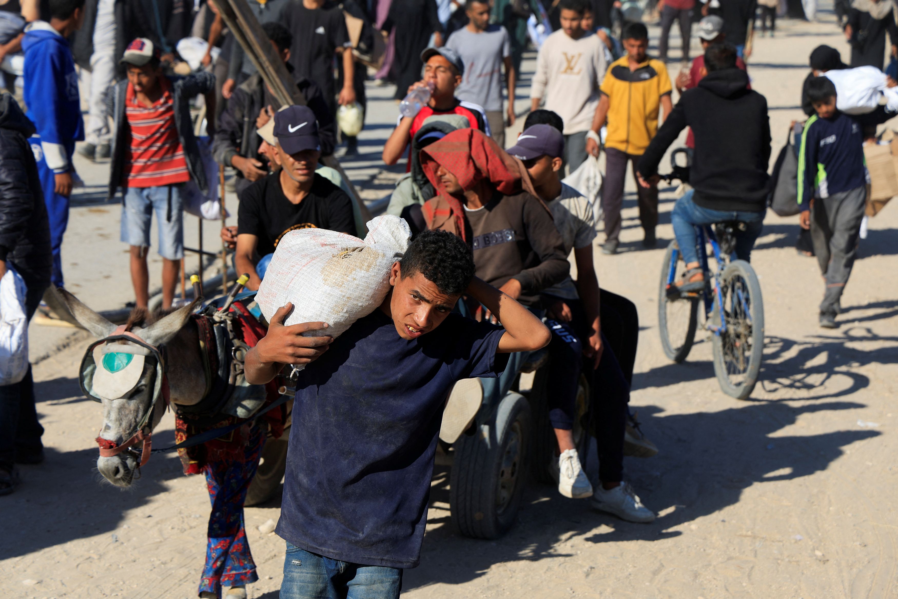 Crowd carrying sacks of grain 