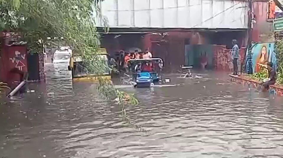 पानी में फंसे स्कूल बसे से बच्चों को निकालकर ट्रैक्टर ट्रॉली से लाते लोग