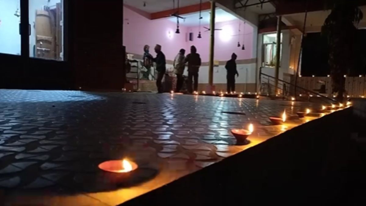 मंदिर में दीप जलाते श्रद्धालु.