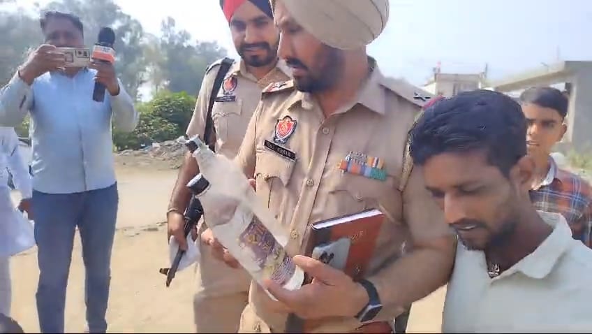 जहरीली शराब दिखाते अधिकारी.