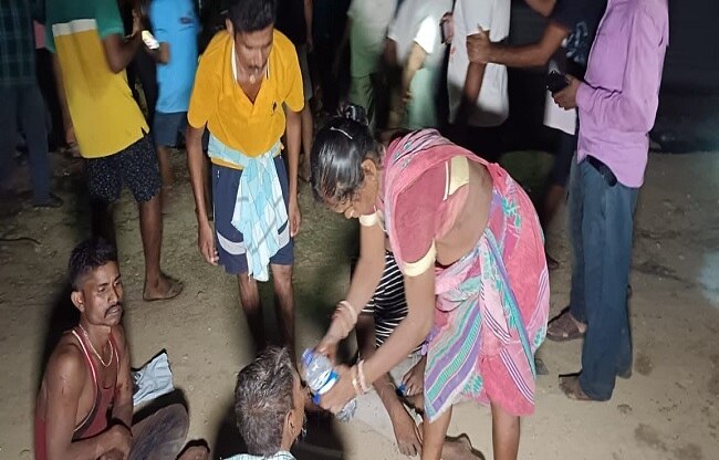 घायलों को पानी पिलाती हुई महिला.