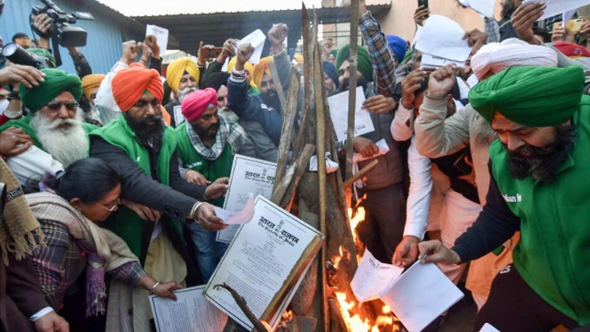 लोहड़ी के दिन कृषि कानूनों की प्रति जलाते किसान (पीटीआई)