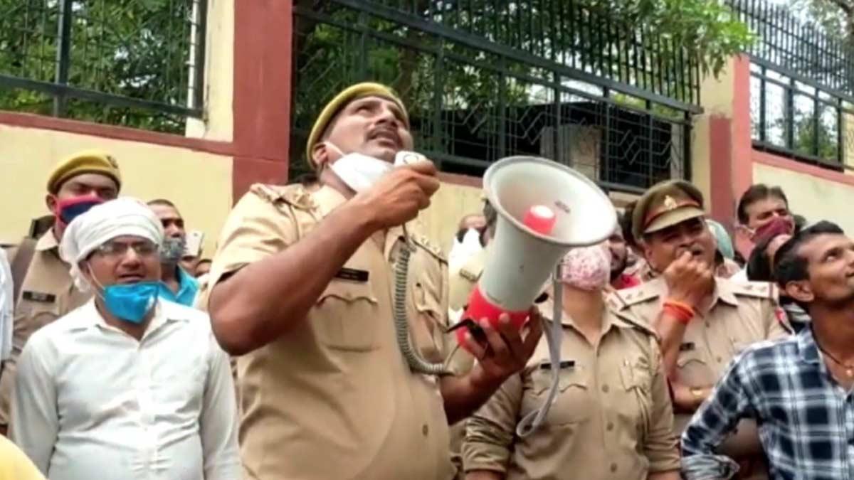 महिला को नीचे उतरने को कहते पुलिसकर्मी