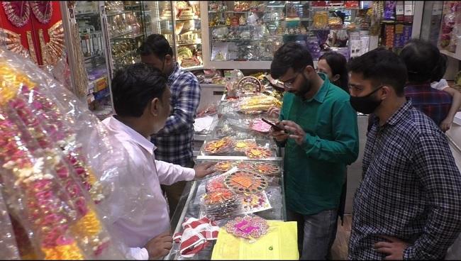 वाराणसी में एक दुकान पर जन्माष्टमी के लिए खरीददारी करते लोग