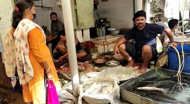 बाजार में मछली बेचता दुकानदार