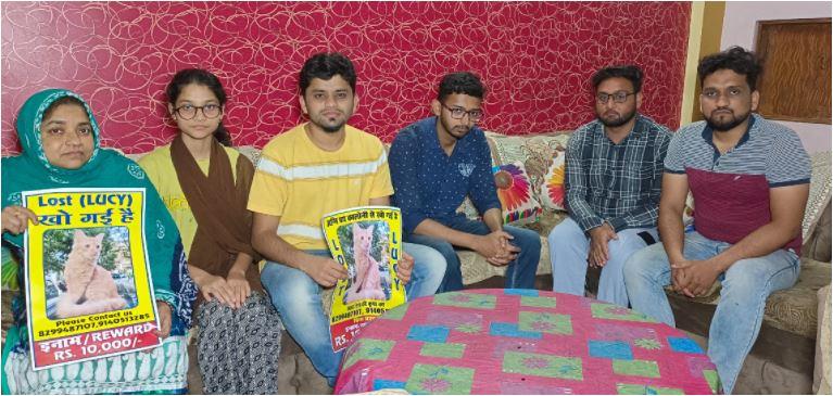 लूसी का पोस्टर लिए परिवार के लोग.